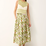 Woman wearing a green and white striped sleeveless top with a floral skirt on a white background