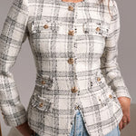 Woman wearing a checkered blazer with gold buttons against a neutral background