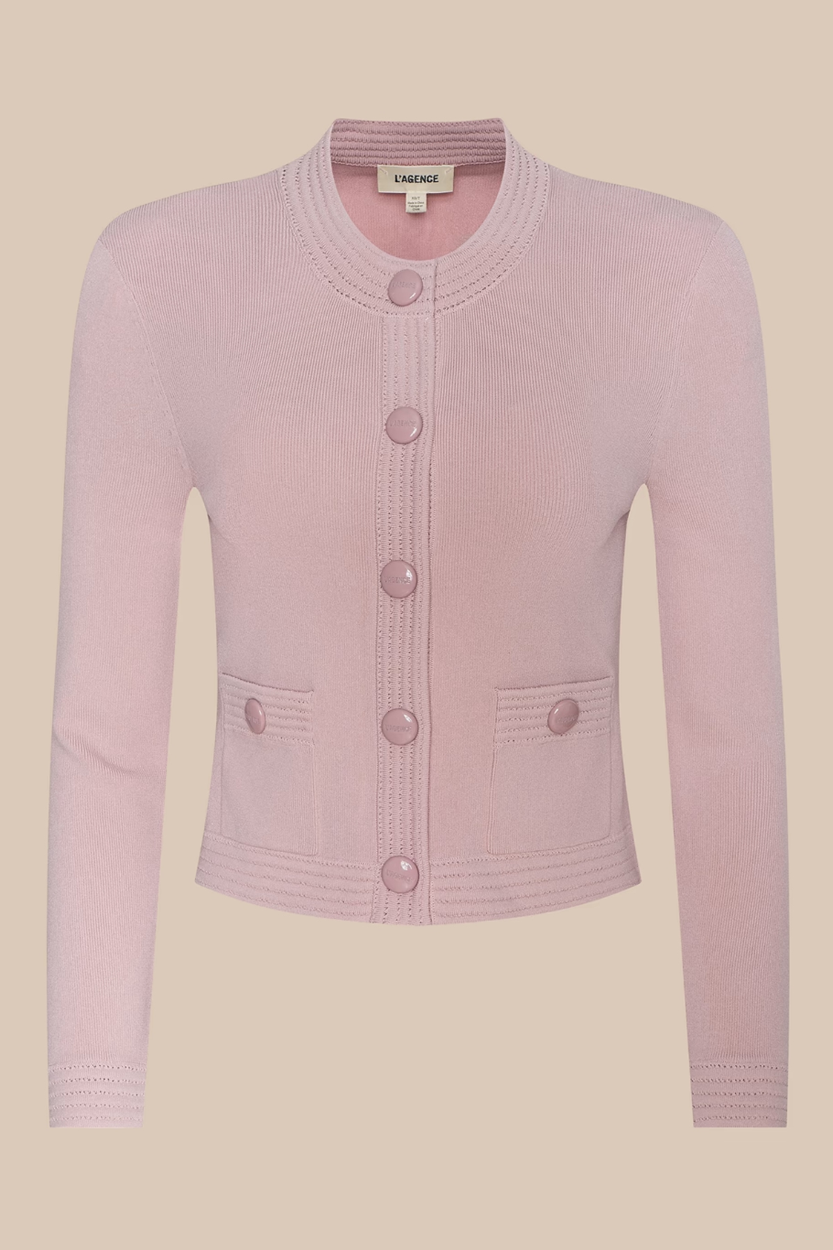 Pink cardigan with button details on a beige background