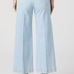 Light blue wide-leg jeans worn by a person on a white background