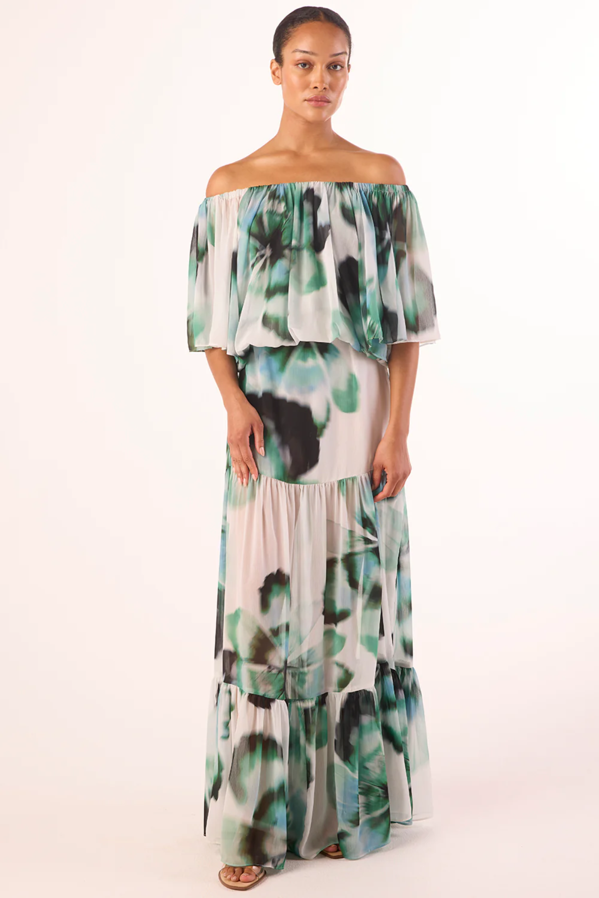 Woman wearing a floral off-shoulder dress on a white background