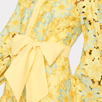 close up of woman in yellow lace dress on white background 