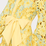 close up of woman in yellow lace dress on white background 