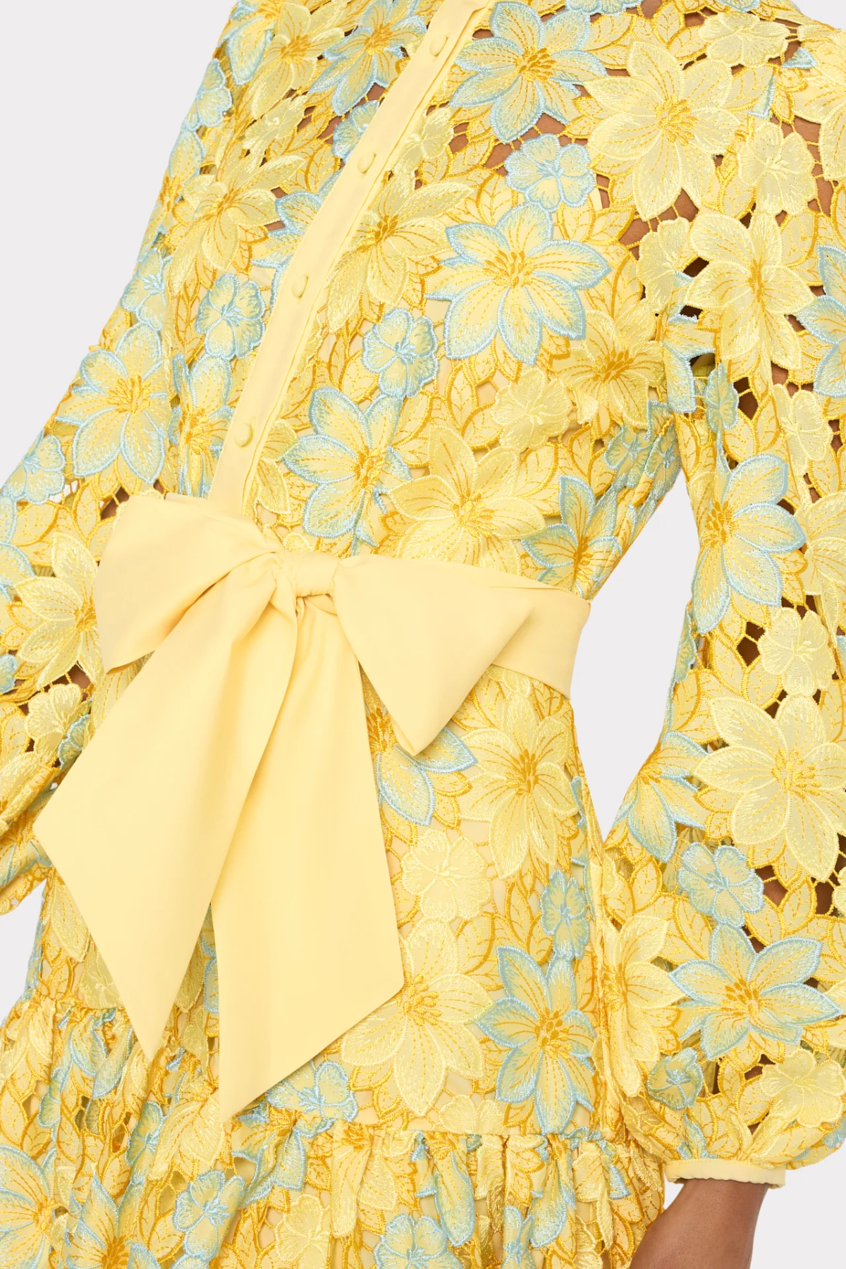close up of woman in yellow lace dress on white background 