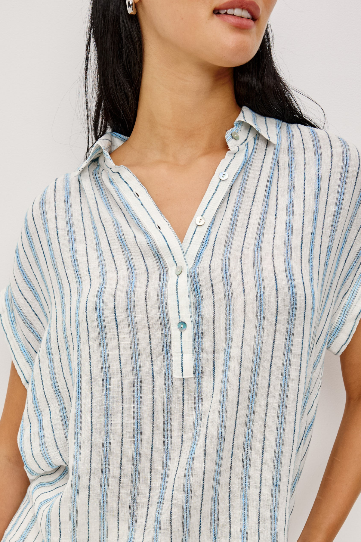 Close-up of a person wearing a blue and white striped shirt against a white background