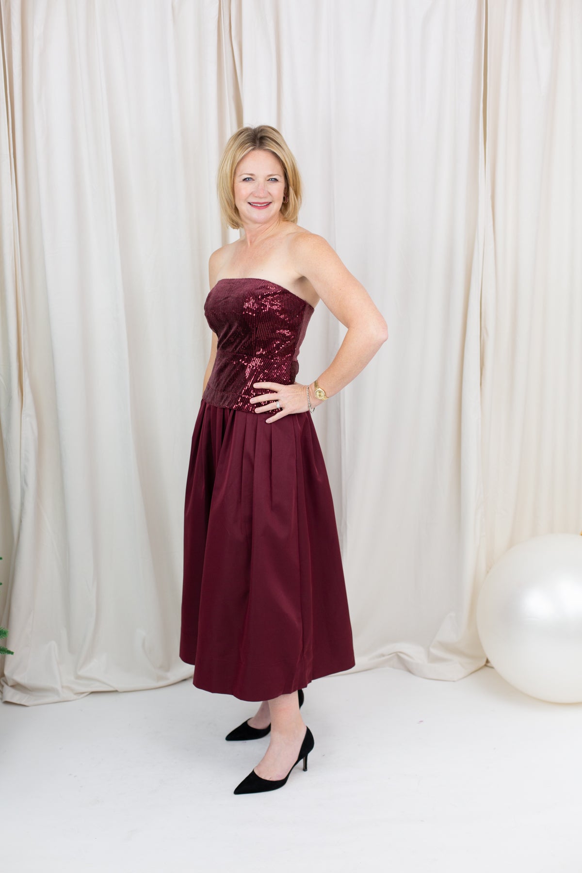 Burgundy sequin dress for evening wear paired with heels
