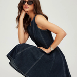 Woman wearing a dark blue denim dress on a white background