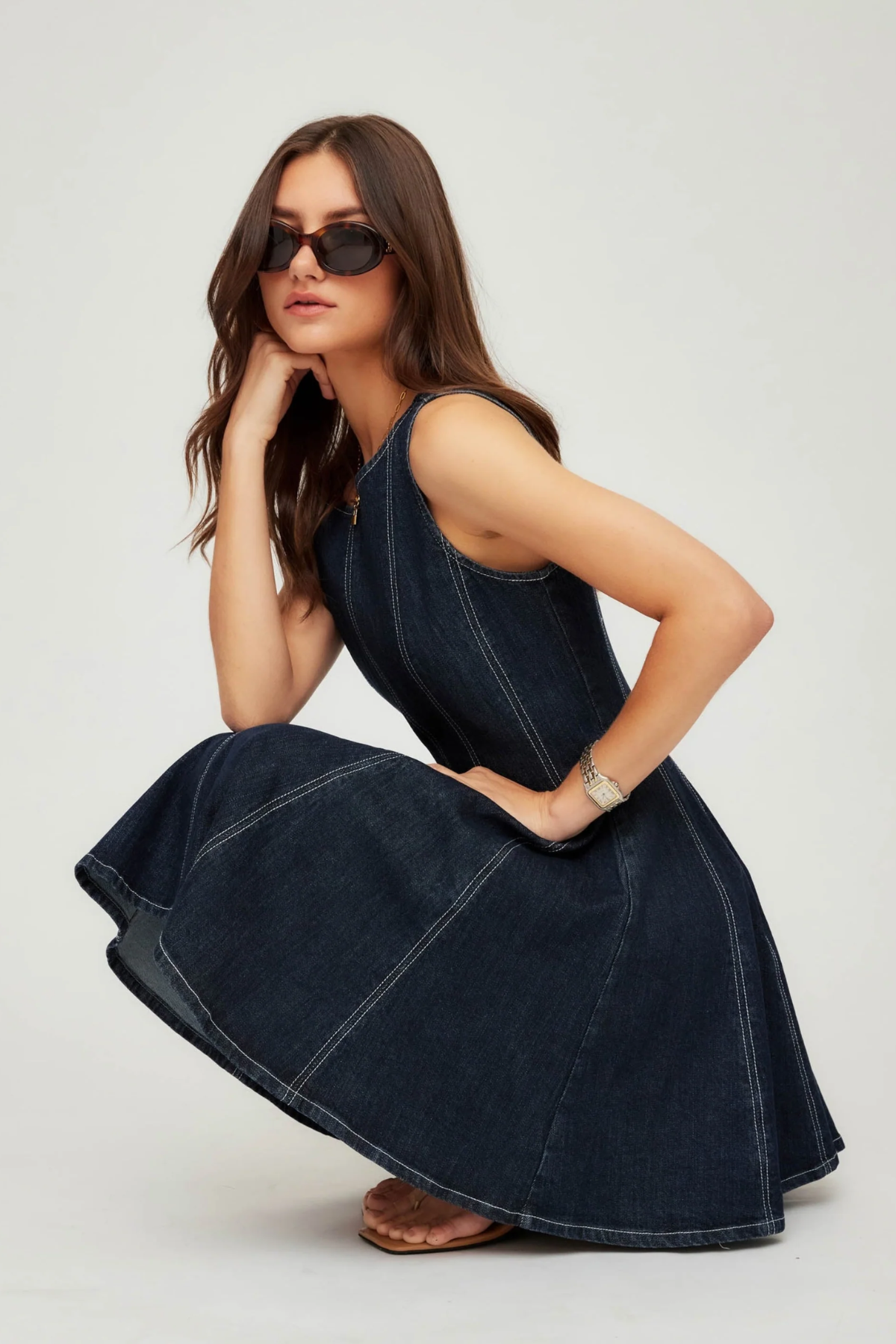 Woman wearing a dark blue denim dress on a white background