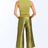 A woman shown from the back wearing a sleeveless olive green top and matching wide-leg cropped pants, paired with beige heels, against a plain white studio background.