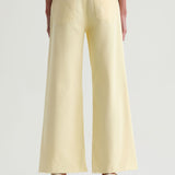 Light yellow wide-leg pants worn by a person on a white background
