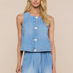 Woman wearing a sleeveless denim top and long denim skirt on a beige background