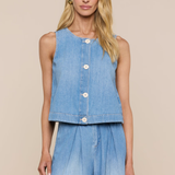 Woman wearing a sleeveless denim top and long denim skirt on a beige background