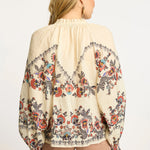 Neutral blouse with a streamlined, polished silhouette.