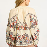 Neutral blouse with a streamlined, polished silhouette.