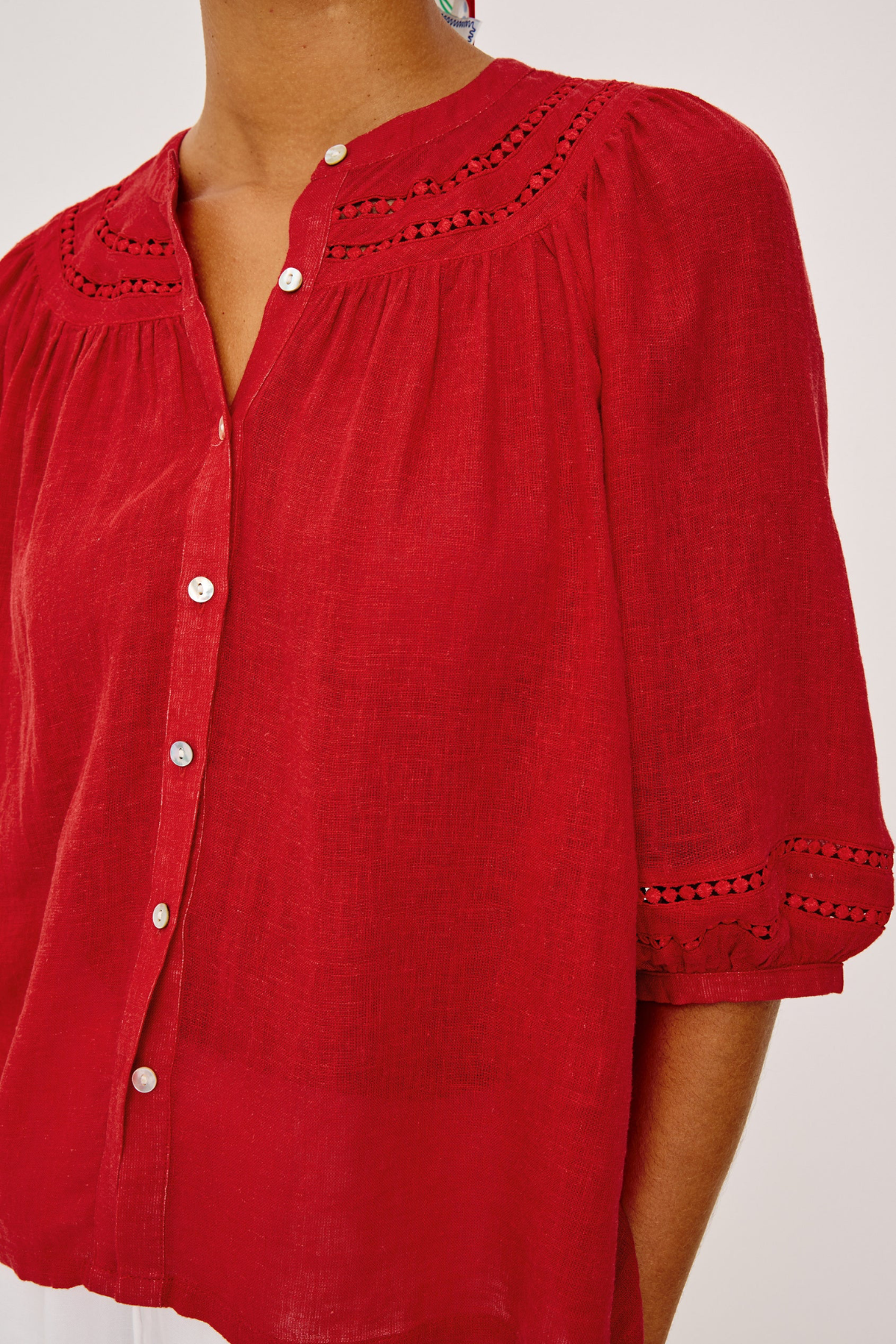 Red blouse with button details on a white background