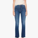 A model wearing a pair of medium-wash blue cropped flare jeans, paired with a cream-colored short-sleeve top and metallic silver high-heeled sandals, set against a plain light gray background.