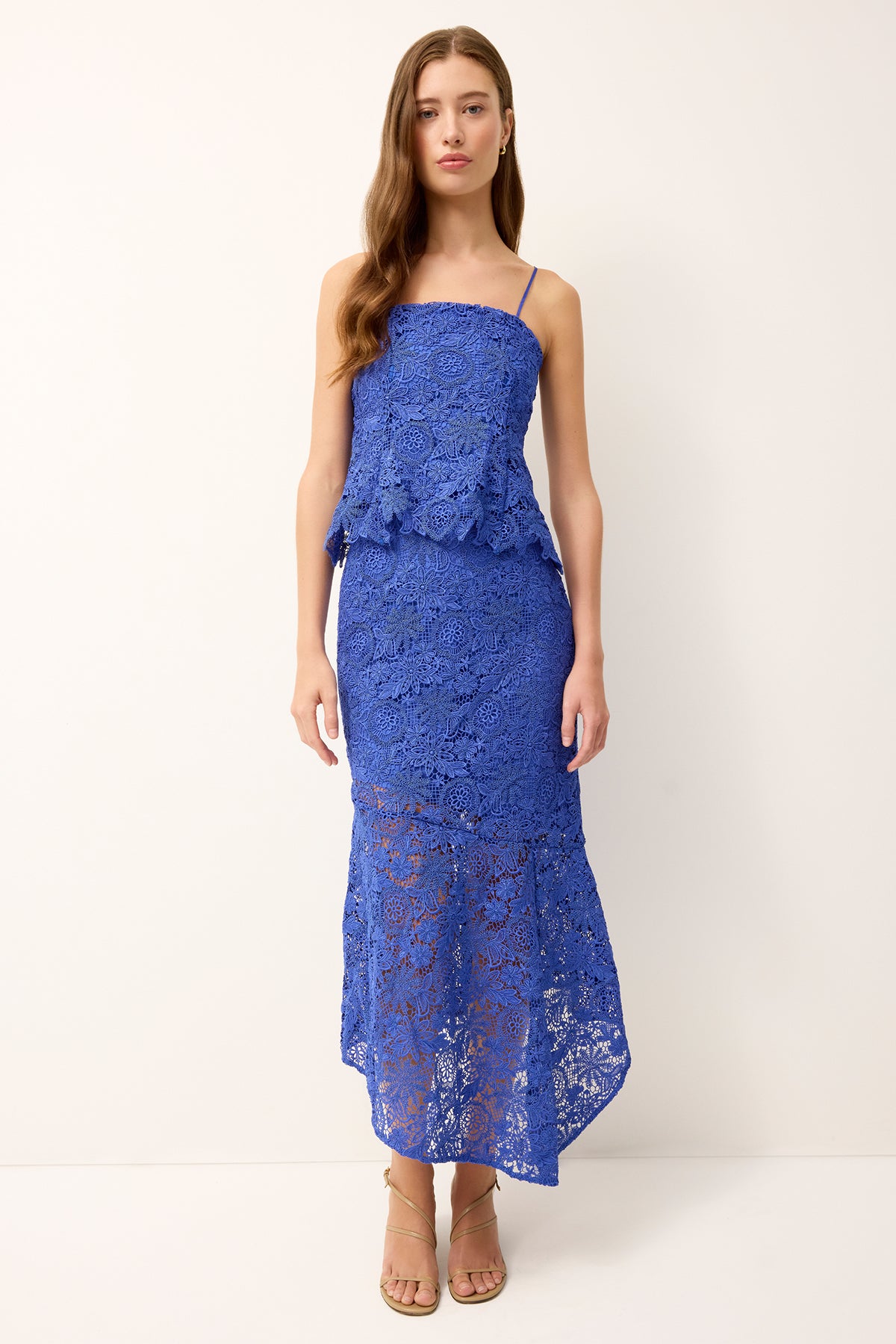 Woman wearing a blue lace dress on a white background