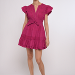 Model wearing a bright pink mini dress with a fitted waist and short sleeves.