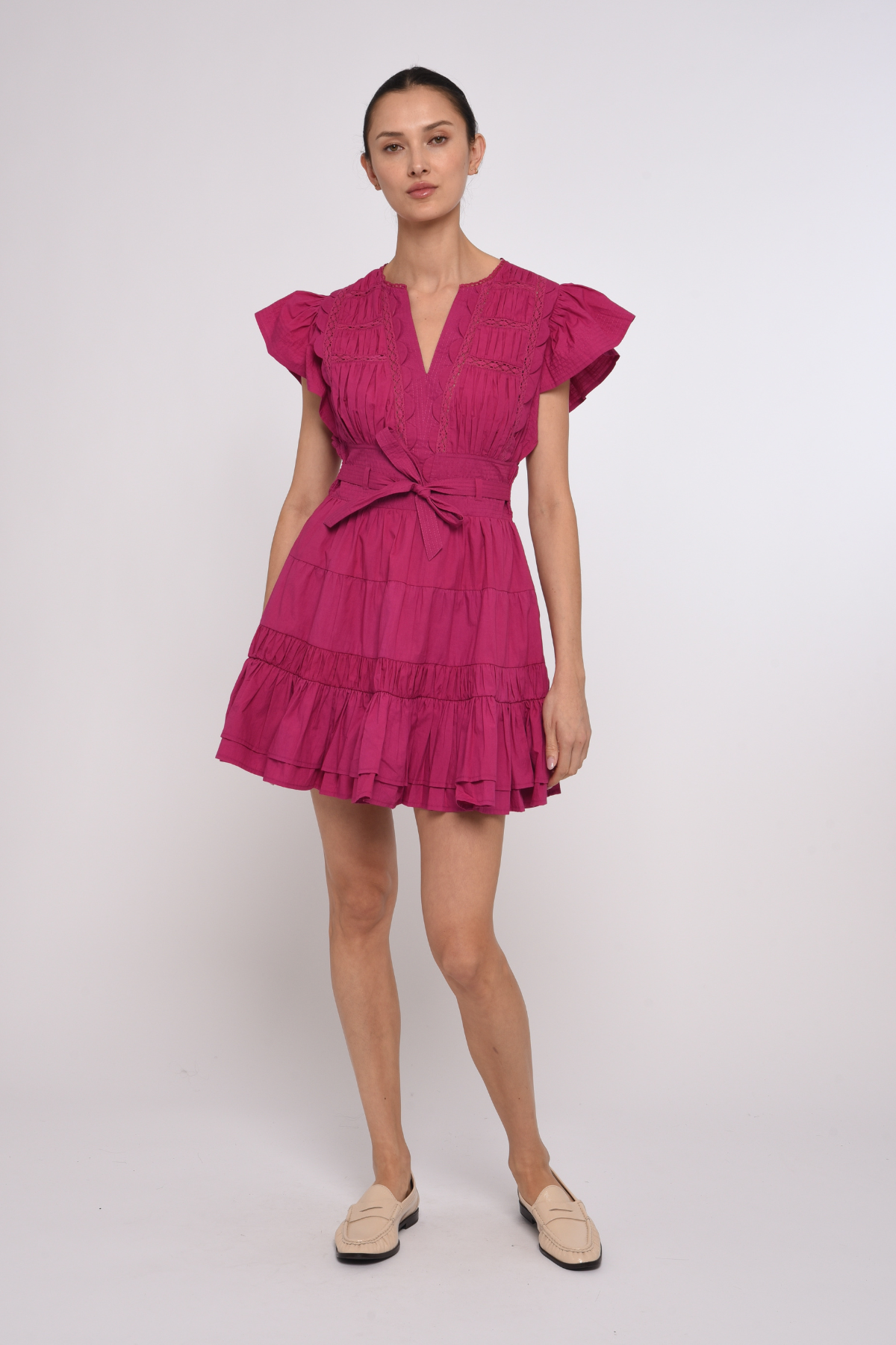 Model wearing a bright pink mini dress with a fitted waist and short sleeves.