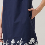 Navy dress with white lace details on a plain background