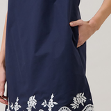Navy dress with white lace details on a plain background