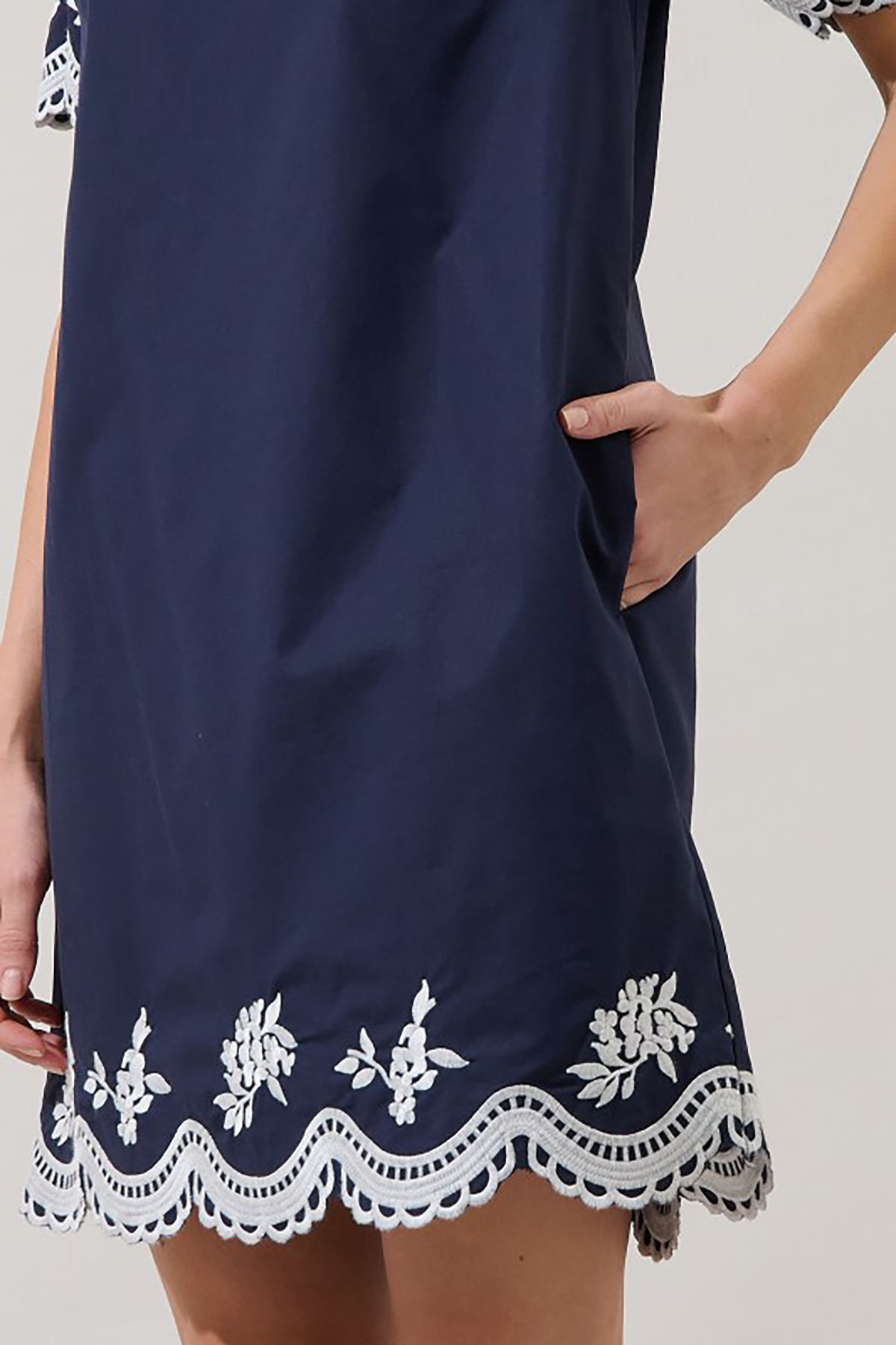 Navy dress with white lace details on a plain background