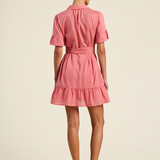 Woman wearing a pink dress on a beige background