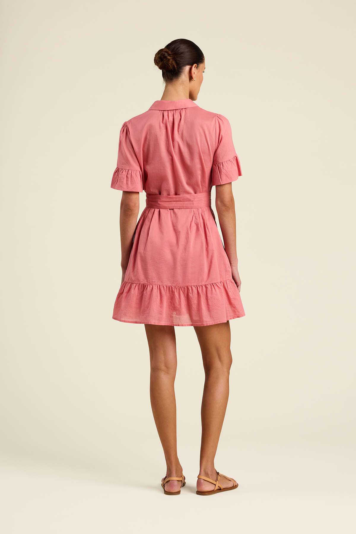 Woman wearing a pink dress on a beige background