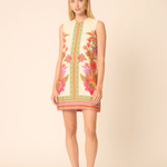 Woman wearing a colorful floral dress on a beige background