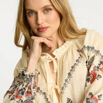 Neutral blouse with a streamlined, polished silhouette.