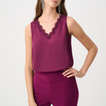 Woman wearing a sleeveless purple top with lace details and matching pants on a white background