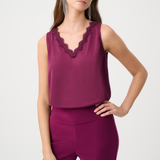 Woman wearing a sleeveless purple top with lace details and matching pants on a white background