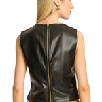 A woman shown from the back wearing a sleeveless black faux leather vest with a gold zipper, paired with tan pants, against a plain white background.
