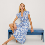 woman on bench in blue printed dress 