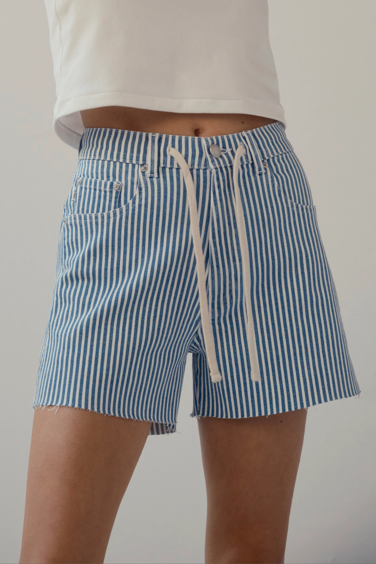 woman in drawstring stripe denim shorts on white background 