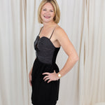 Black sleeveless bustier dress with top-stitch detailing, styled against a clean backdrop