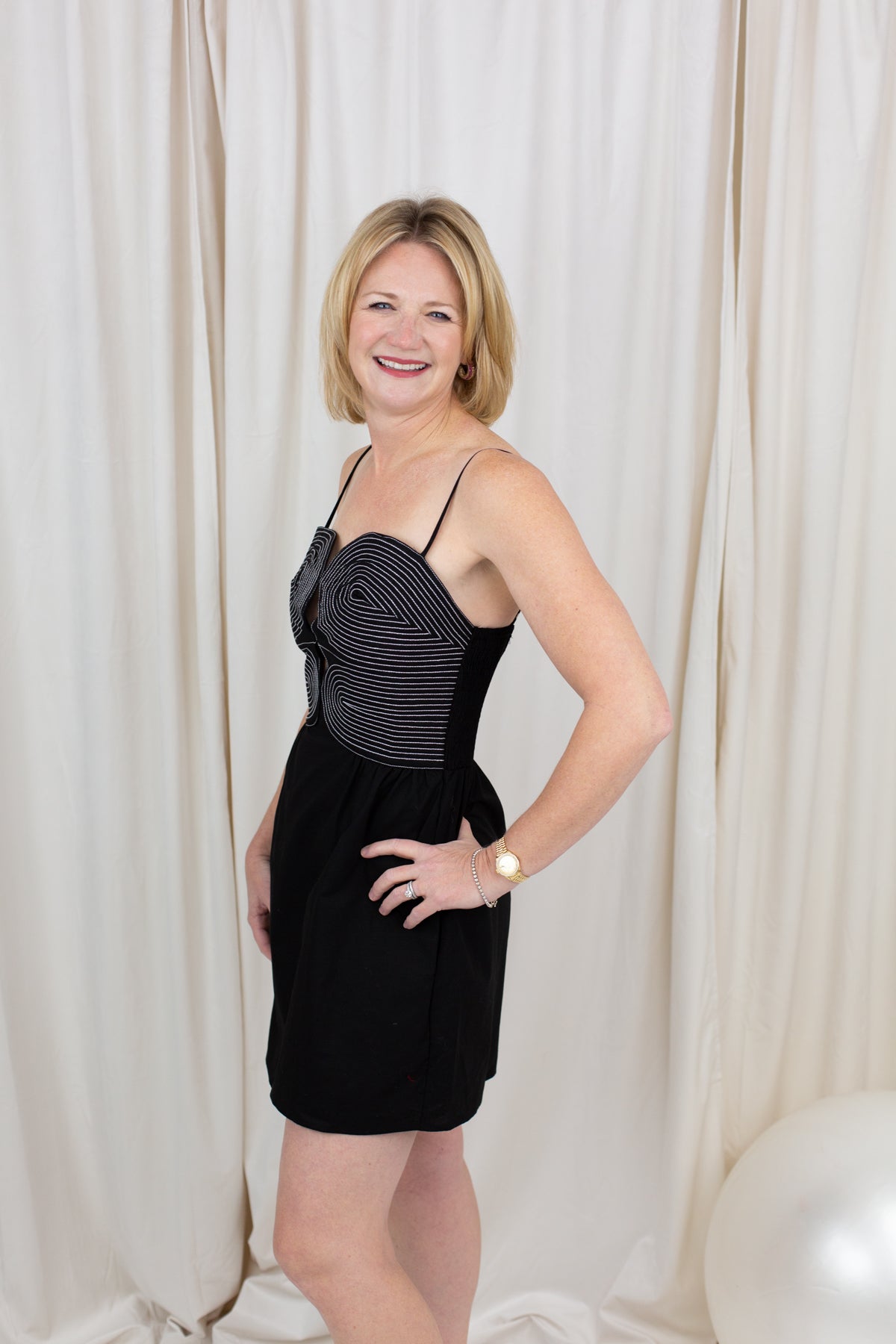 Black sleeveless bustier dress with top-stitch detailing, styled against a clean backdrop