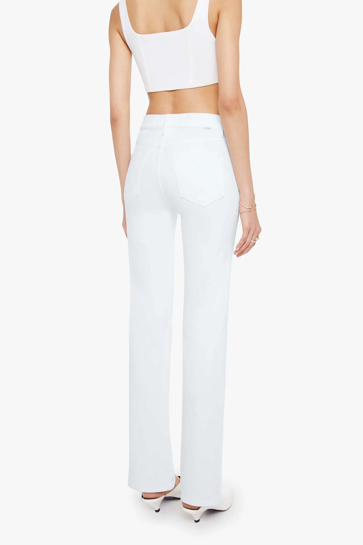 Person wearing a white crop top and high-waisted pants on a white background