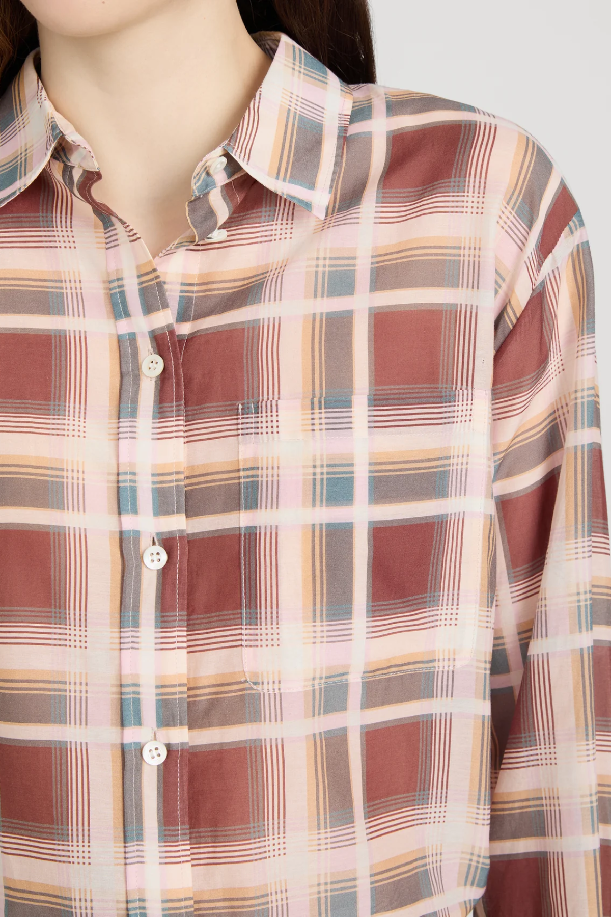 Plaid shirt with a pattern of red, beige, and blue on a plain background