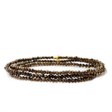 Three brown beaded bracelets on a white background