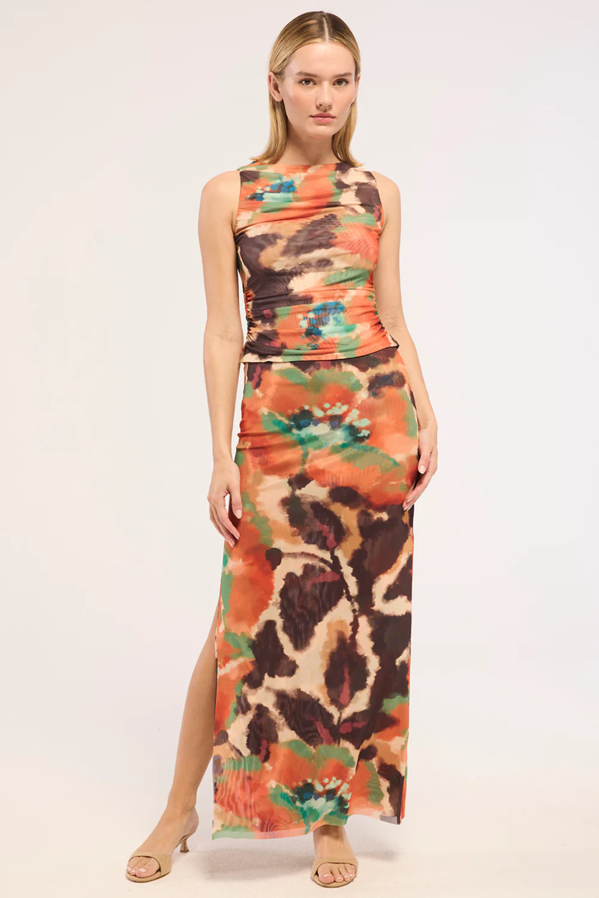 Woman wearing a colorful sleeveless top and skirt on a white background