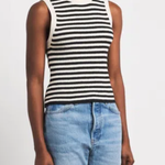 A model wearing a black and white horizontally striped sleeveless knit top paired with light blue jeans, photographed against a clean white studio background.