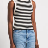 A model wearing a black and white horizontally striped sleeveless knit top paired with light blue jeans, photographed against a clean white studio background.