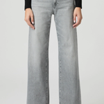 Person wearing light gray wide-leg jeans on a white background