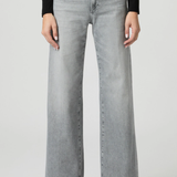 Person wearing light gray wide-leg jeans on a white background