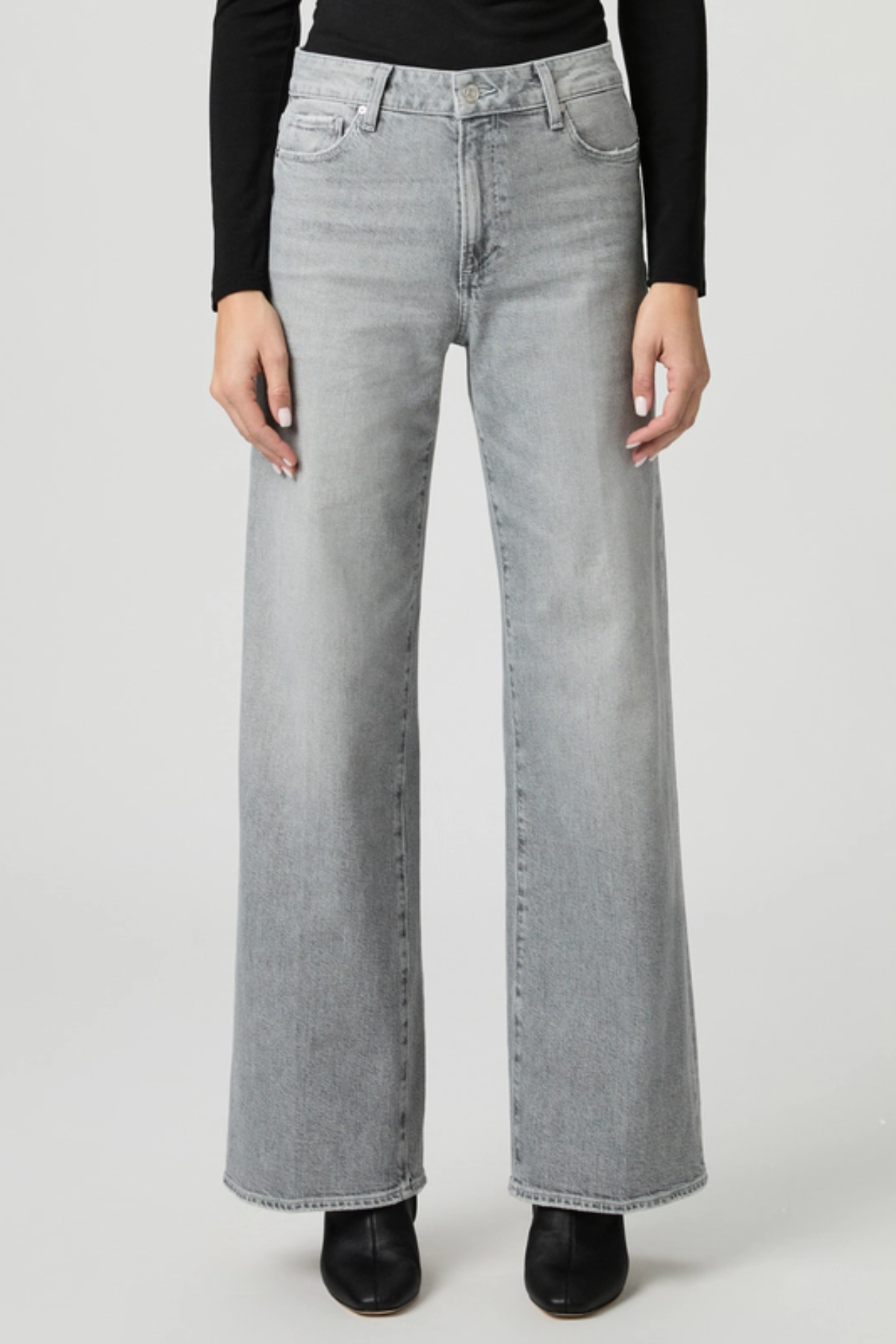 Person wearing light gray wide-leg jeans on a white background
