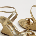 Gold wedge sandals on a white background
