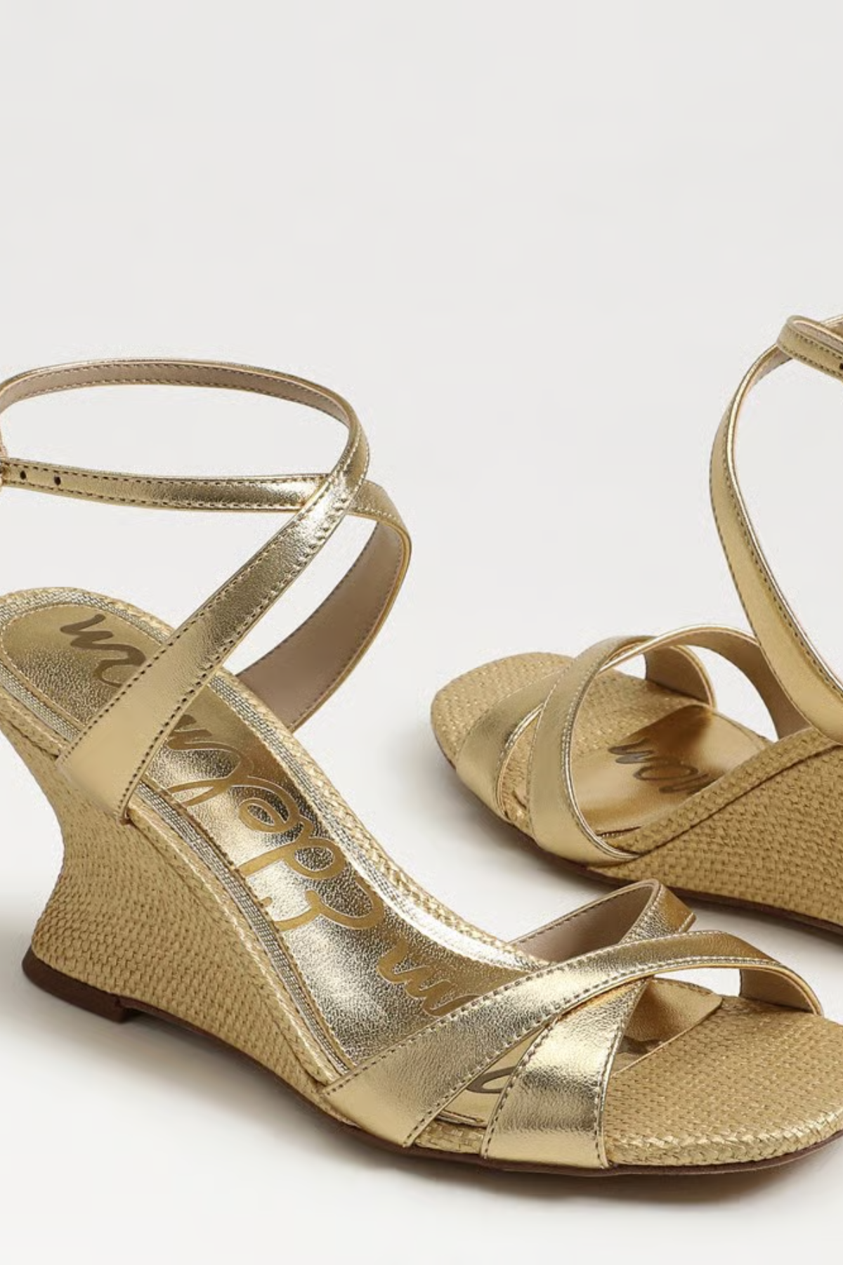 Gold wedge sandals on a white background