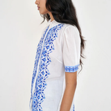 White top with blue printed detailing modeled on white background