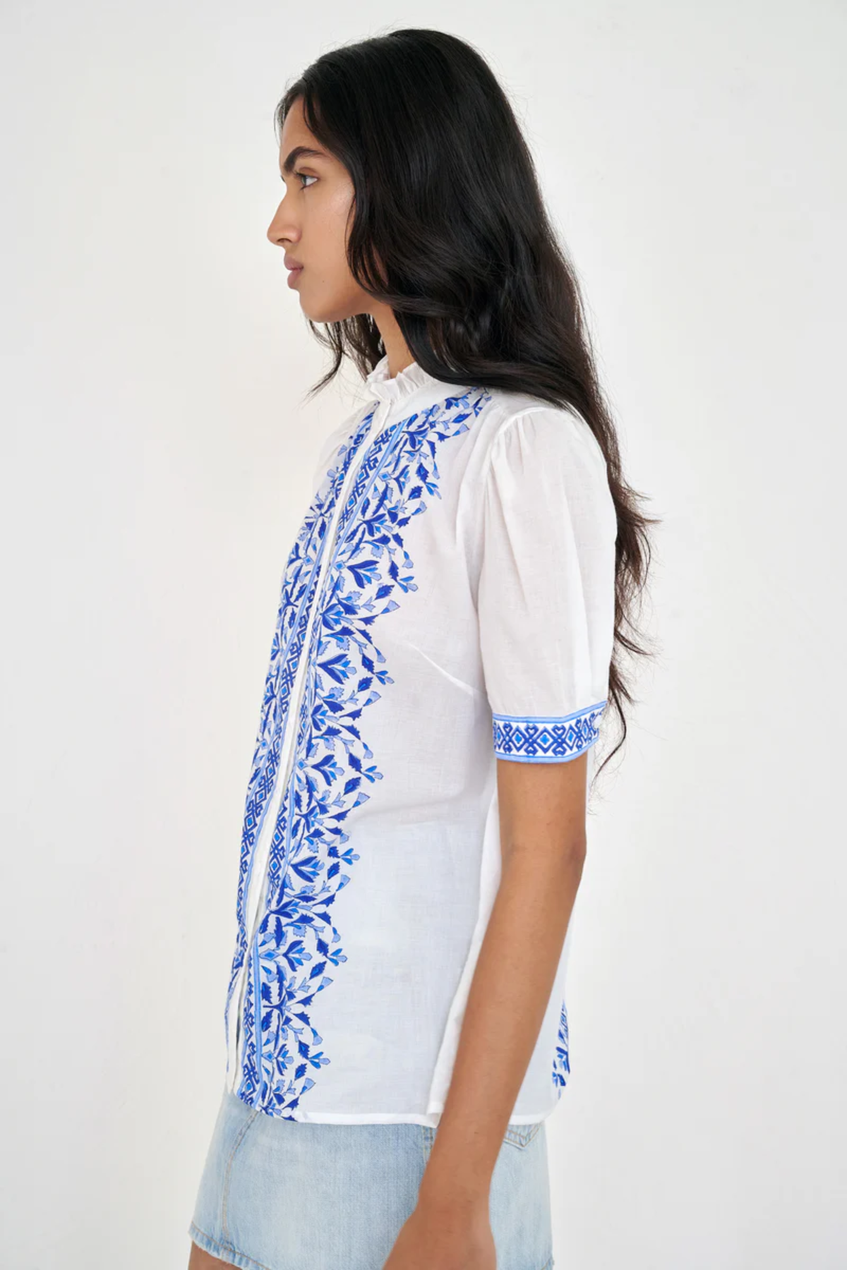 White top with blue printed detailing modeled on white background